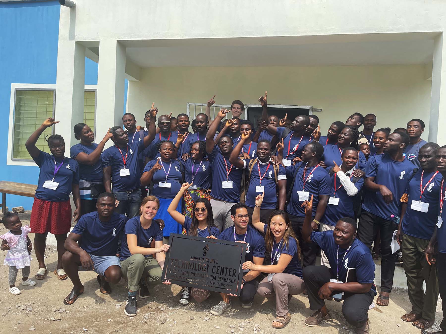 photo of local primary school teachers and staff in Ghana in front of the school building smiling