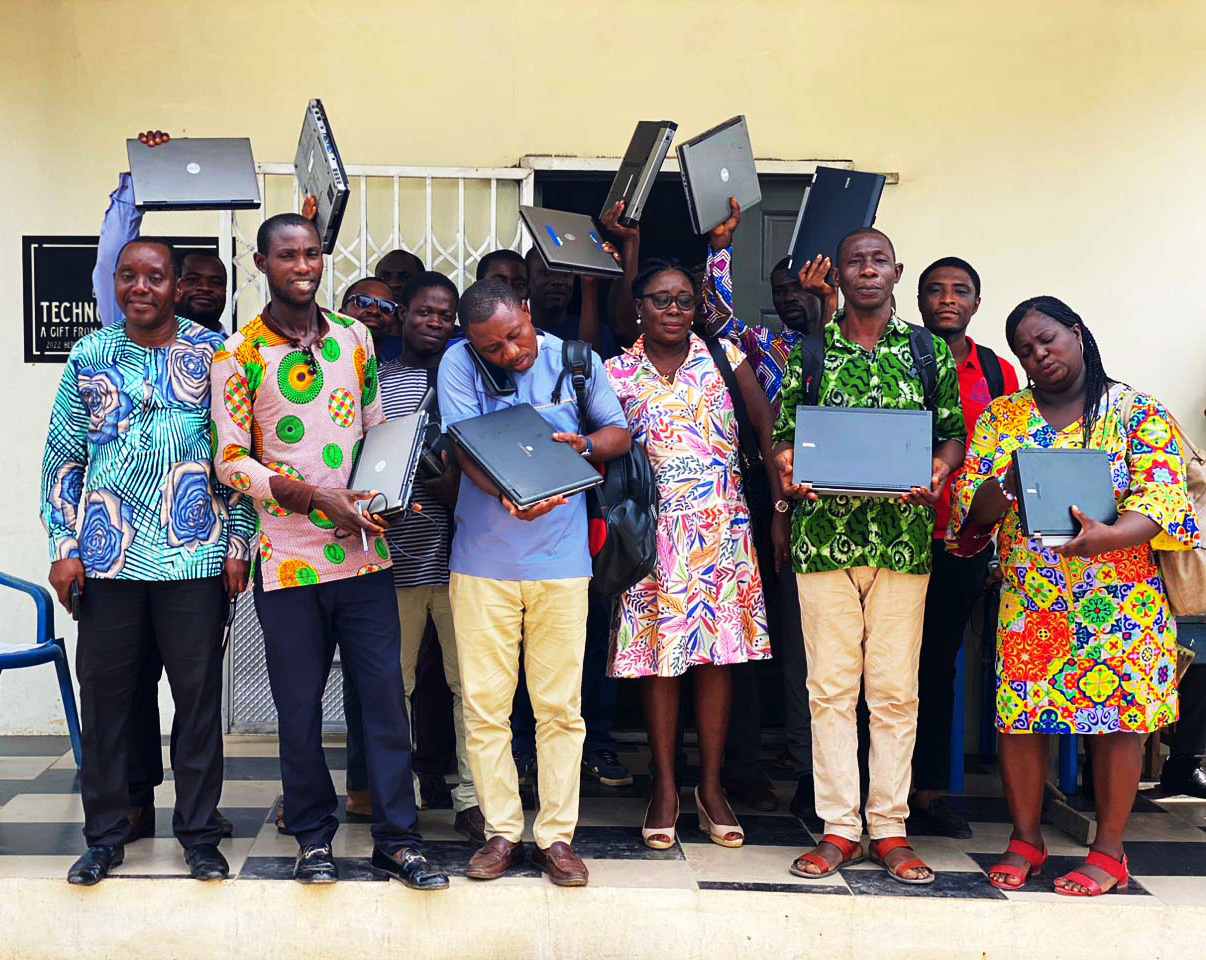 image of African teachers holding up laptops from worldcomputerexchange, standing in front of a classroom